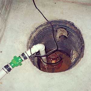 basement of a toronto home, a sump pit is clearly visible with a sump pump at the bottom that requires repair