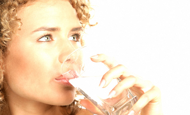 Вкус соды во рту. Девушка пьет из стакана. Пить воду. Блондинка пьет воду.