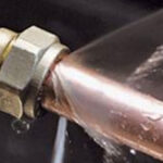 water leaking from the join between two pipes in the basement of a toronto home, a large stream of water is visible flowing out from the leak